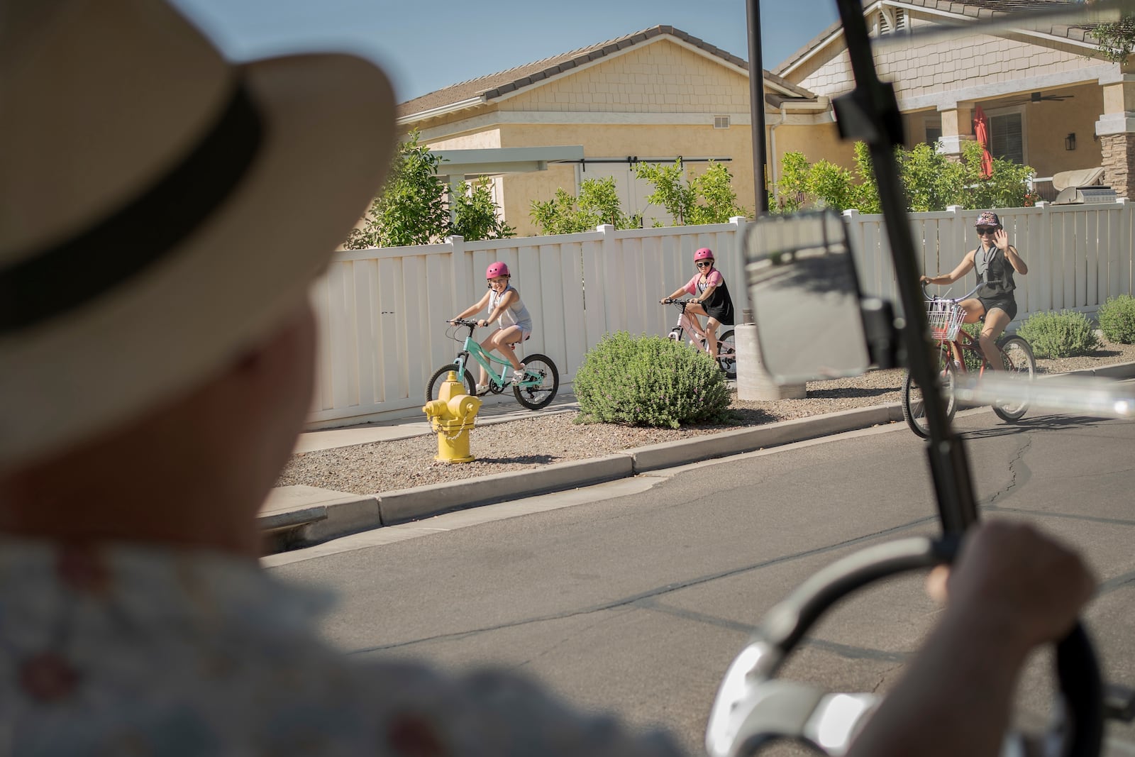 Residents greet Joe Johnston, founder of Agritopia, a community nestled around a plot of agricultural land, as he makes his rounds in his golf cart April 22, 2025, in Gilbert, Ariz. (AP Photo/Annika Hammerschlag)