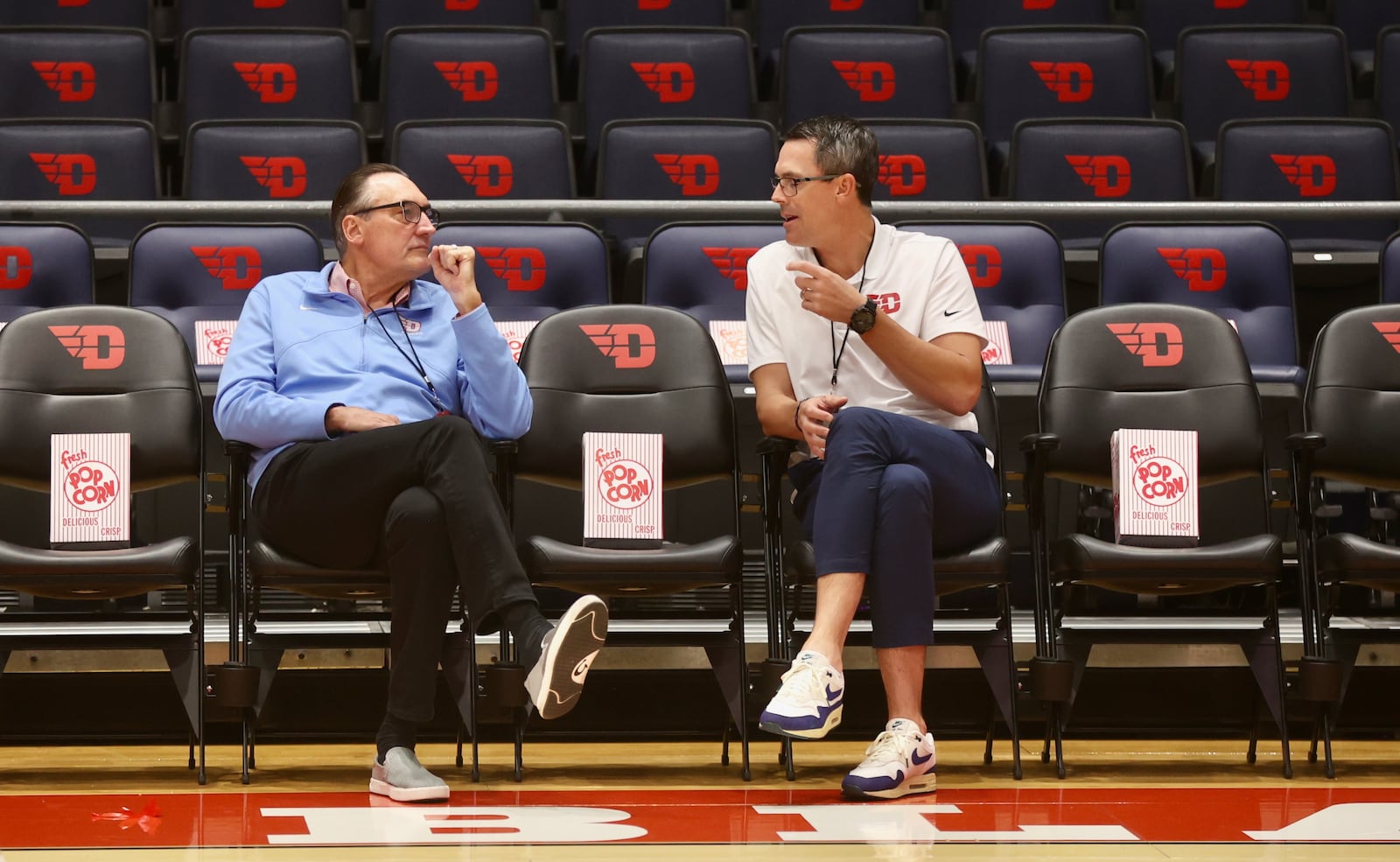 Former Flyers Jim Paxson, left, and Keith Waleskowski talk before an exhibition game against Bowling Green on Monday, Oct. 27, 2025, at UD Arena. David Jablonski/Staff
