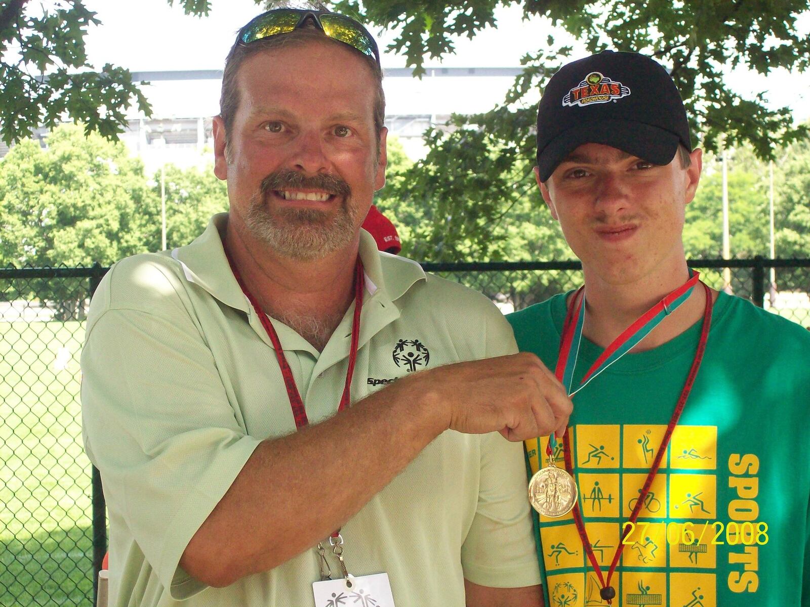 Jim Arquilla shows off one of the medals his son Jimmy won in Special Olympics competition in 2008.. Now 11 year later,after this photo was taken ,Jim is still one of the coaches of the Huber Heights Special Olympics team and Jimmy is still one of the standout athletes on the team. CONTRIBUTED
