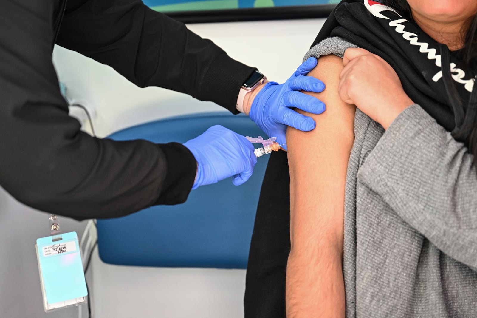 A student receives a vaccination inside a mobile health unit visiting Independence High School in Charlotte, N.C., on Wednesday, March 19, 2025. (AP Photo/Matt Kelley)
