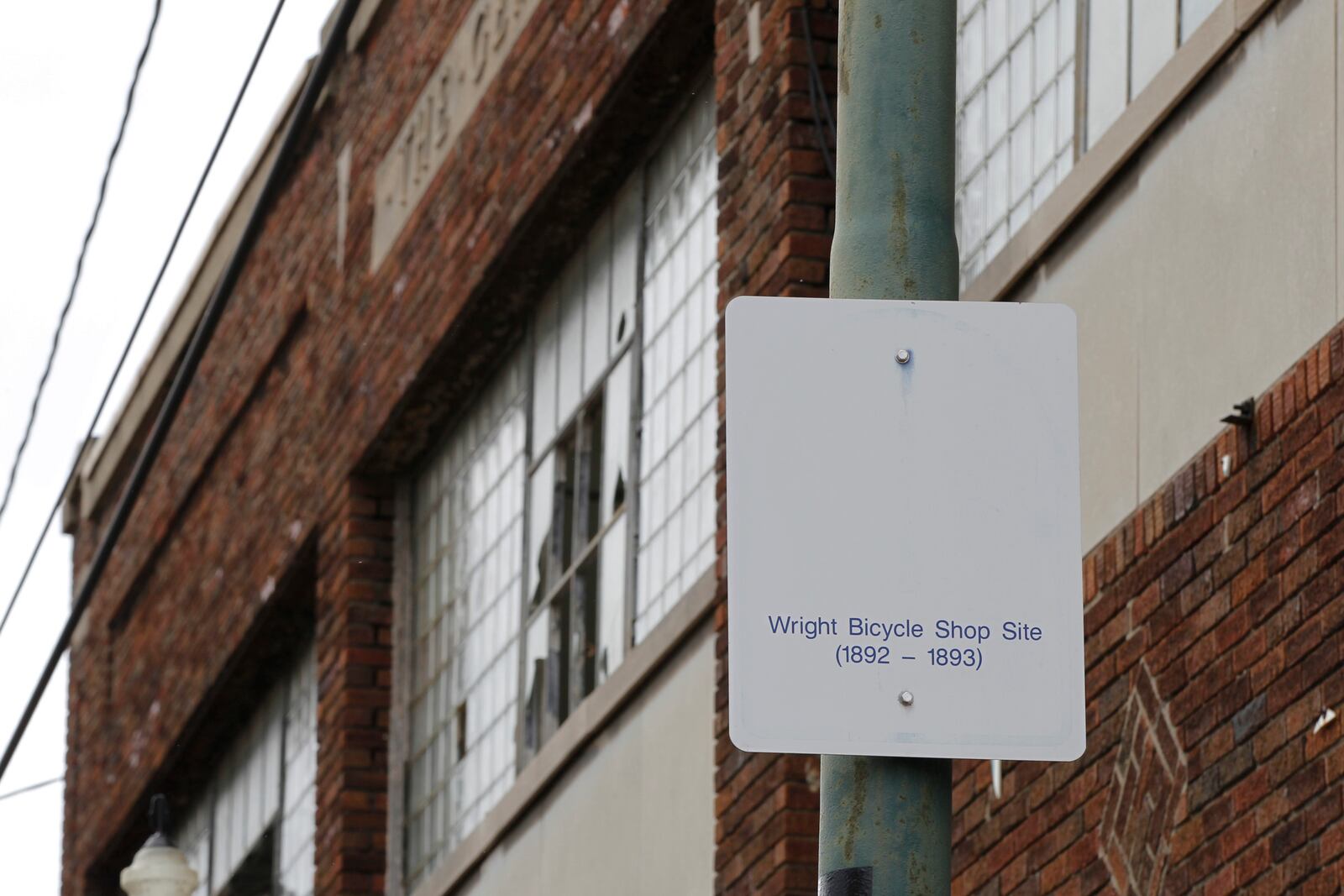 In this undated photo, a sign notes the site of the Wright brothers' bike shop outside the former Gem City Ice Cream building in Dayton, Ohio. The city of Dayton plans to demolish the 129-year-old historic building that once was the site of the Wright brothers’ first bike shop because the building has deteriorated and is unable to be maintained and redeveloped. The shop was first built in 1892 to serve as the Wright brothers' first bike shop. Soon thereafter, Gem City Ice Cream Co. bought the property and housed it until 1975 until was sold to another company, the Dayton Daily News reported. (Ty Greenlees/Dayton Daily News via AP, File)