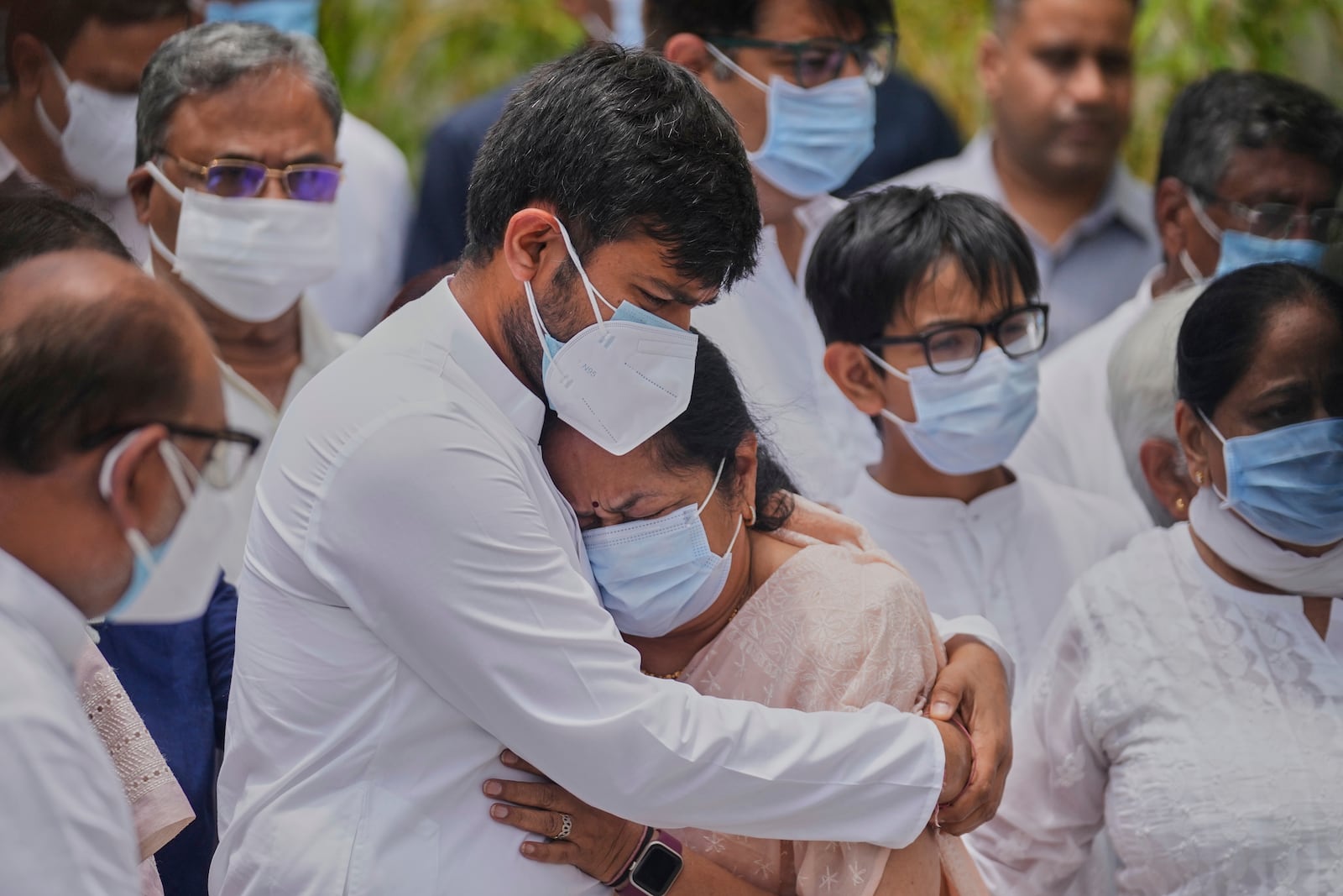 Anjali Rupani, the wife of former Chief Minister of Gujarat Vijay Rupani, who died in the Air India plane crash, is comforted by her son during a wreath-laying ceremony outside the mortuary of a hospital in Ahmedabad, India, Monday, June 16, 2025. (AP Photo/Rafiq Maqbool)