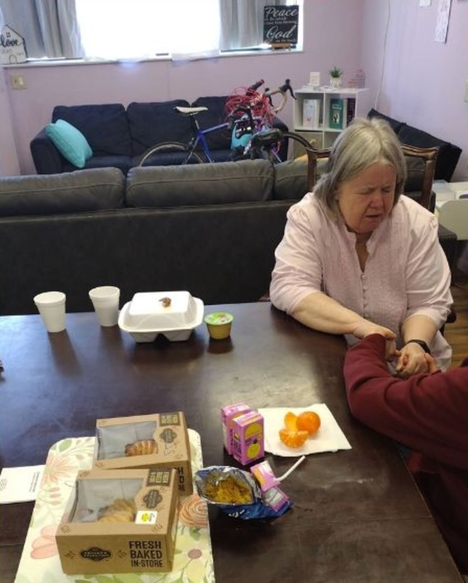 A volunteer pastor prays with one of the women served by Sidewalk Soldiers. DAN RENFRO/CONTRIBUTED