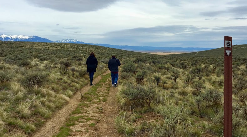 Visitors to the National Historic Oregon Trail Interpretive Center outside Baker City, Ore., walk in the ruts formed when hundreds of thousands of pioneers crossed this route headed to the towering Blue Mountains. (Terri Colby/Chicago Tribune/TNS)