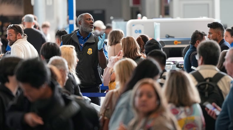 Passengers are directed through a security checkpoint line at George Bush Intercontinental Airport Thursday, March 19, 2026, in Houston. (AP Photo/David J. Phillip)