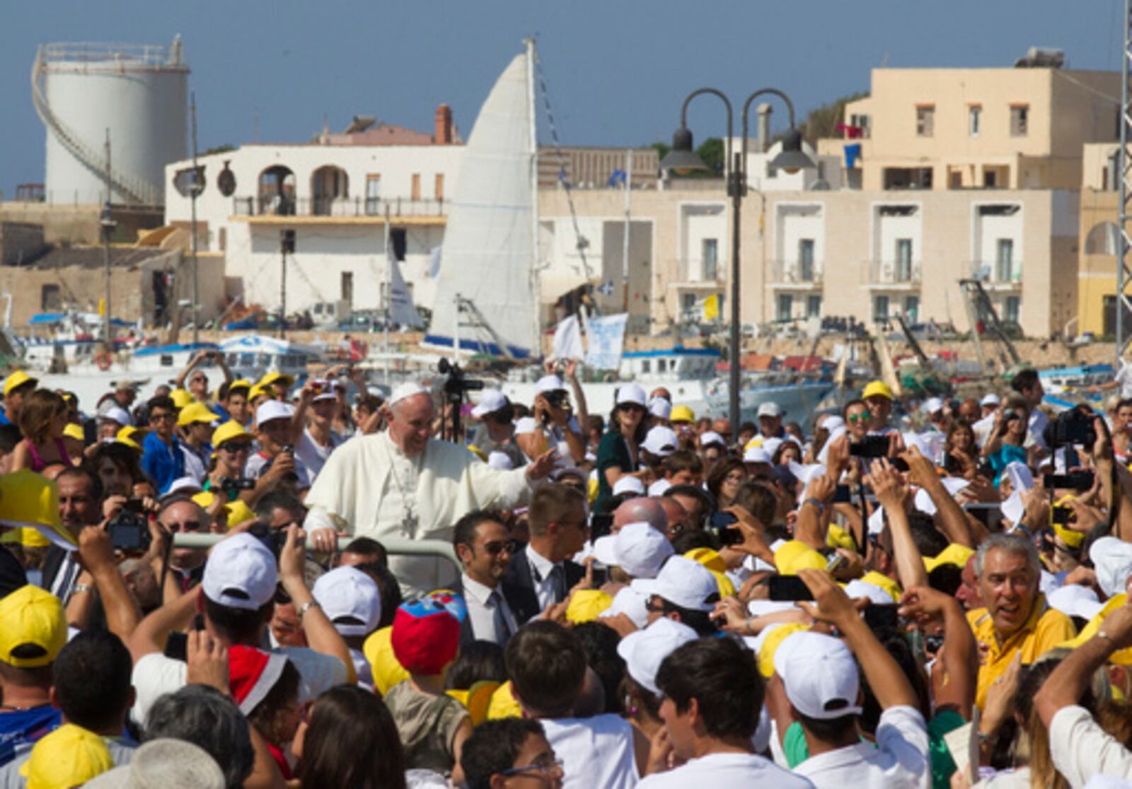 FILE - Pope Francis waves to faithful as he is driven through the crowd during his visit to the island of Lampedusa, southern Italy, on July 8, 2013, where he denounced the "globalization of indifference" that greets migrants who risk their lives trying to reach Europe. (AP Photo/Alessandra Tarantino, File)