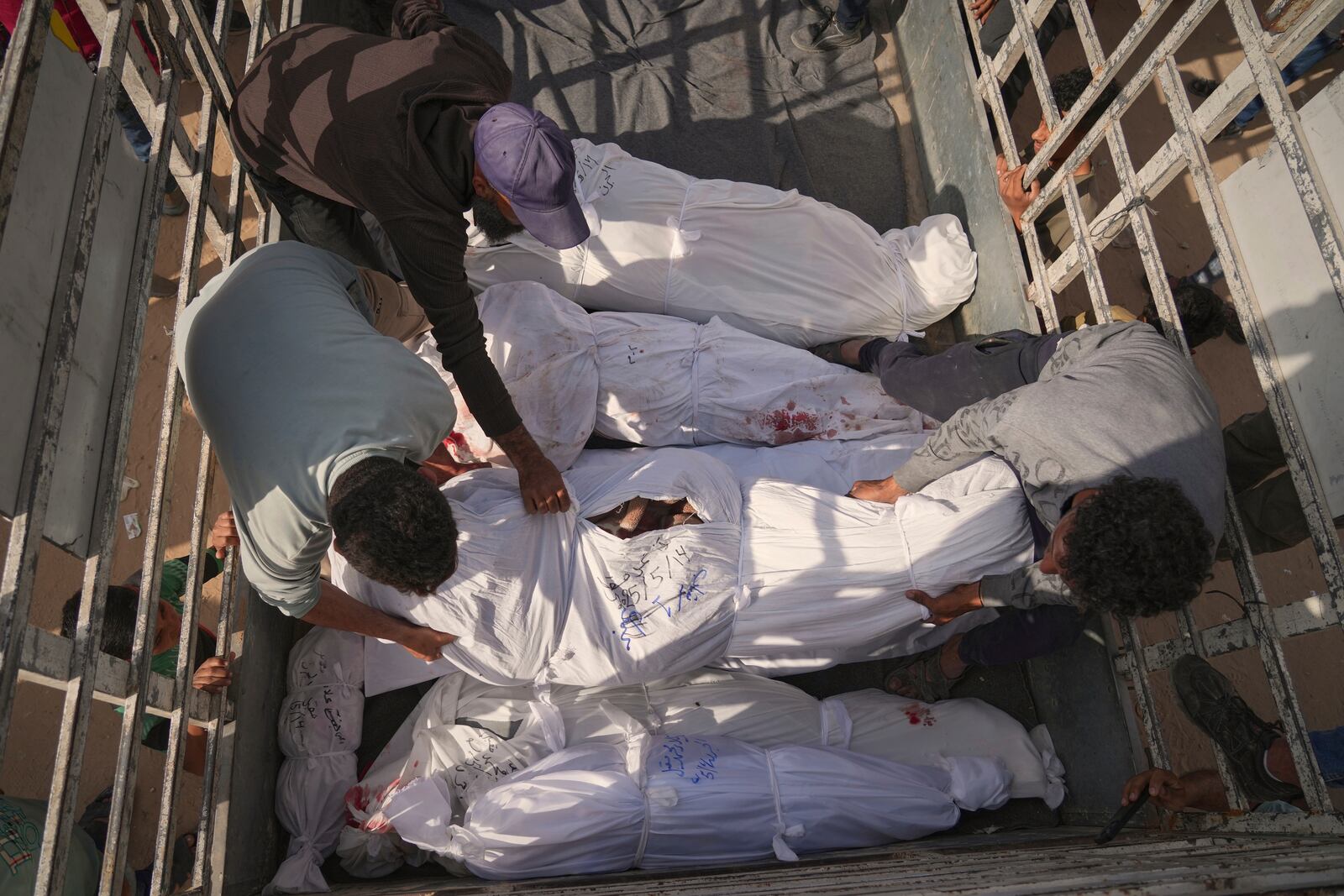 Palestinians load bodies of their relatives killed in the Israeli army airstrikes in Jabalia, northern Gaza Strip, on Wednesday, May 14, 2025. According to local hospitals, 48 people were killed in the strikes, including 22 children. (AP Photo/Jehad Alshrafi)
