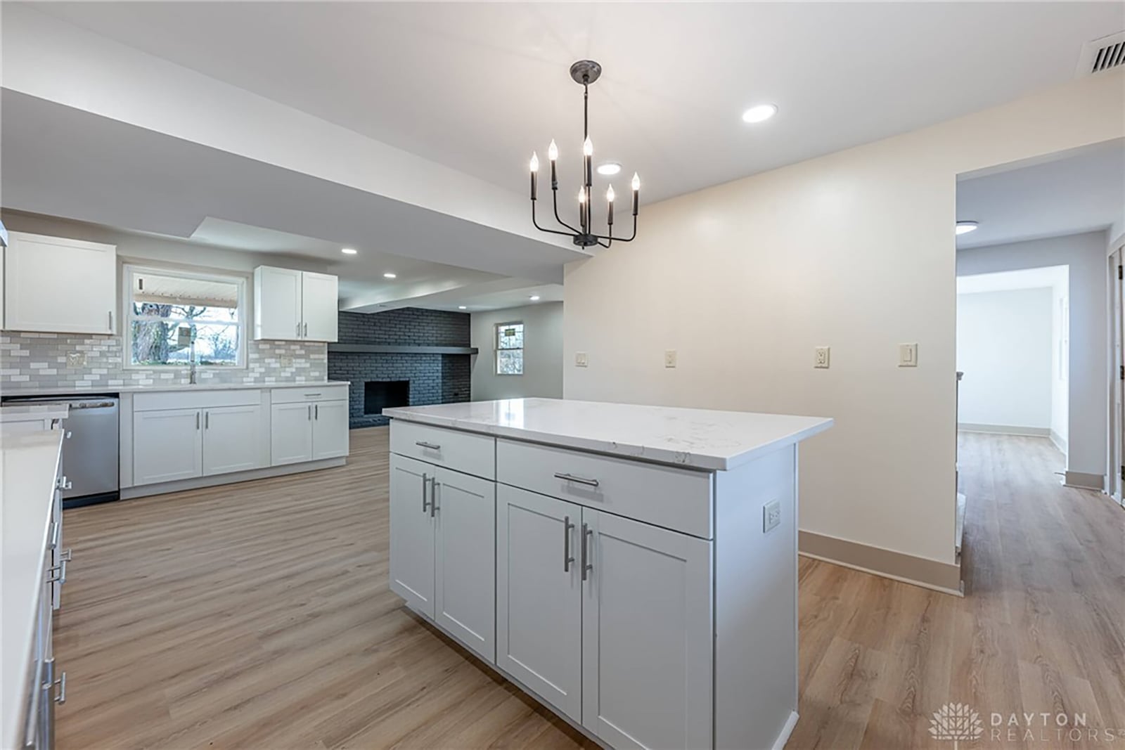 The kitchen features all new appliances, an island with bar seating and a decorative chandelier, recessed lighting and an exterior door opening to the back patio. CONTRIBUTED