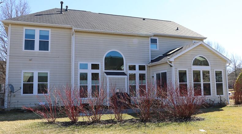 A berm planted with bushes provides patio privacy at the back of the home while the backyard green space allows space for outdoor play.