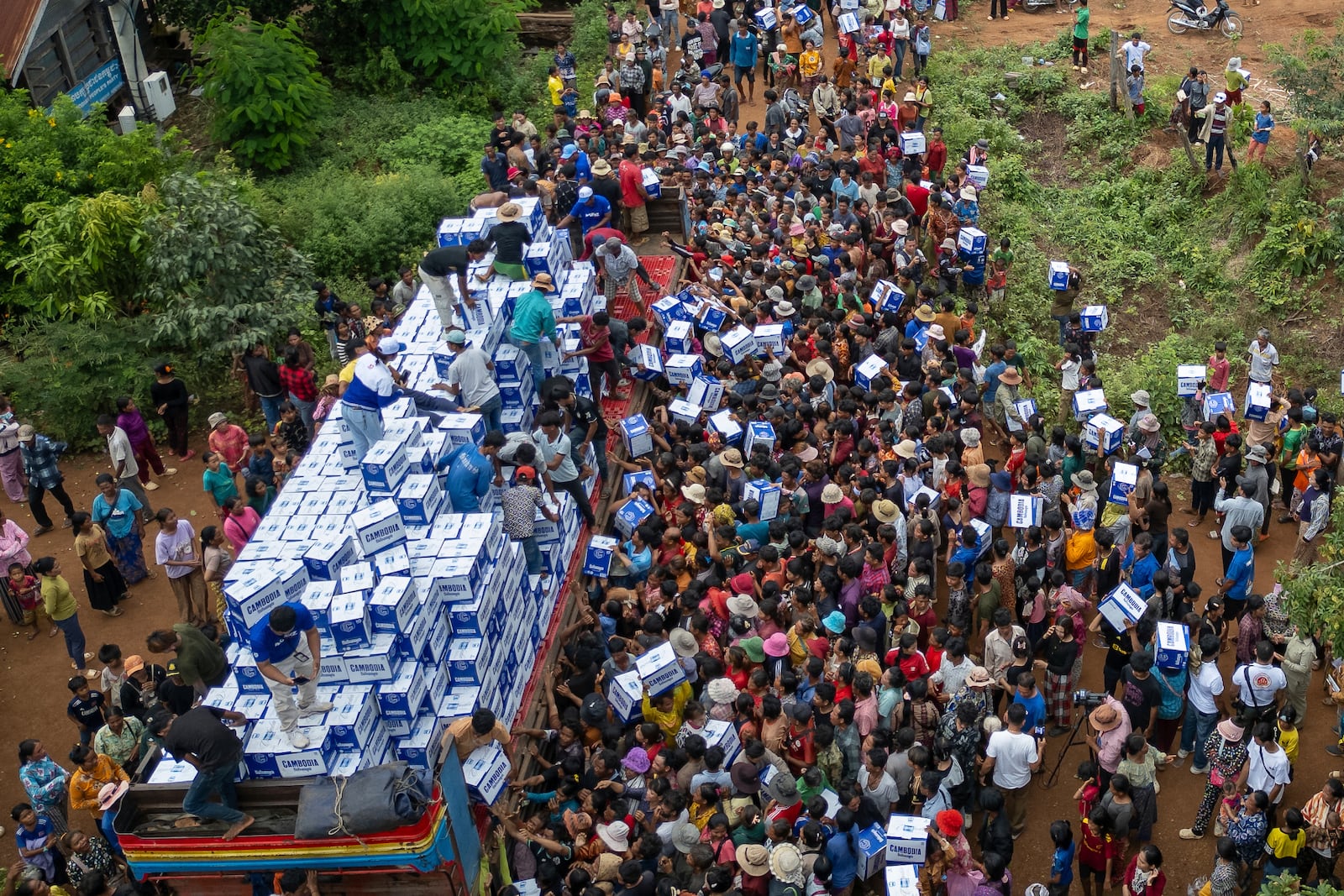 Displaced Cambodians receive water at the Battkhao Resettlement Camp in Oddar Meanchey Province, Cambodia, Saturday, July 26, 2025 as border clashes between Thailand and Cambodia entered its third day. (AP Photo/Anton L. Delgado)