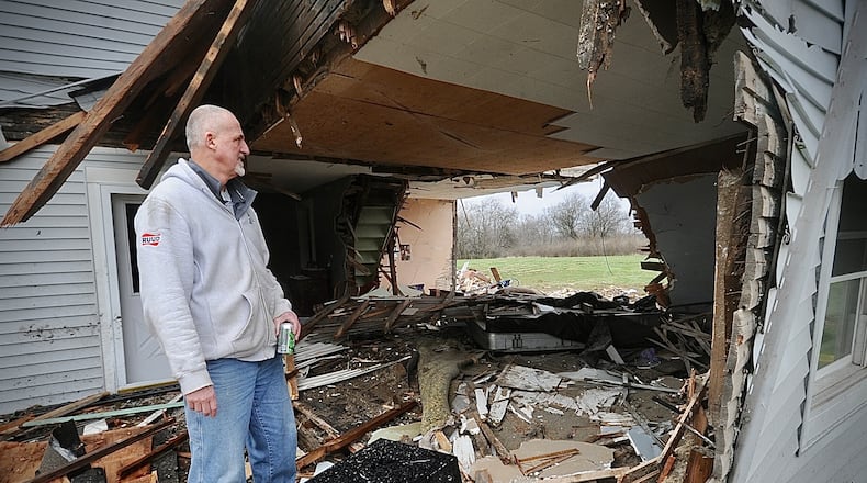 Dave Fisher looks at what is left of his house on Friday, March 31, 2023, after a semi drove through it Thursday evening at state Routes 571 and 201 in Bethel Twp. Fisher’s wife was inside and only suffered minor injuries but the house will be demolished and rebuilt, Fisher says. MARSHALL GORBY \STAFF