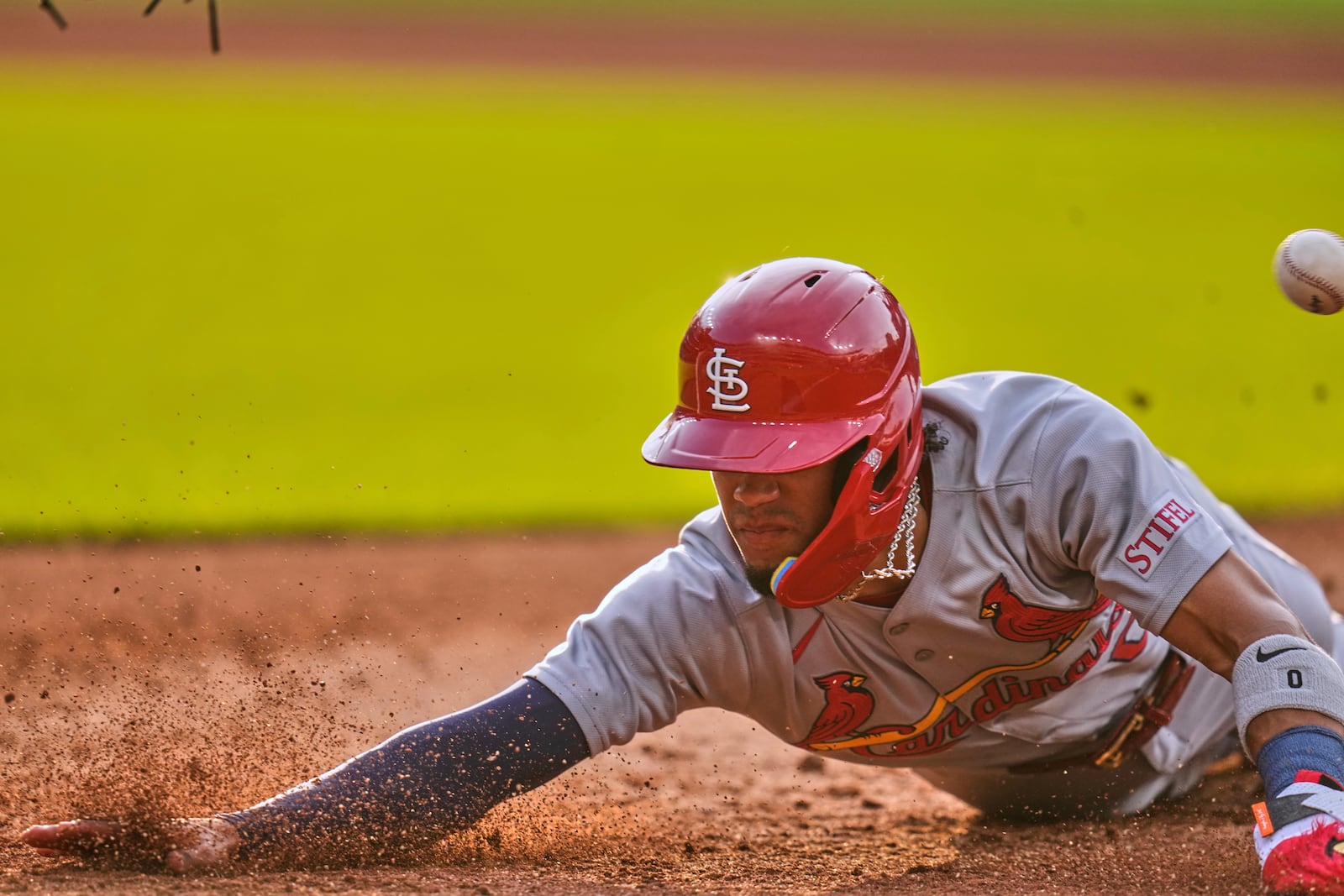 St. Louis Cardinals' Masyn Winn dives back into first base as the ball gets away from Cleveland Guardians first baseman Kyle Manzardo on a pickoff-attempt in the third inning of a baseball game in Cleveland, Friday, June 27, 2025. (AP Photo/Sue Ogrocki)