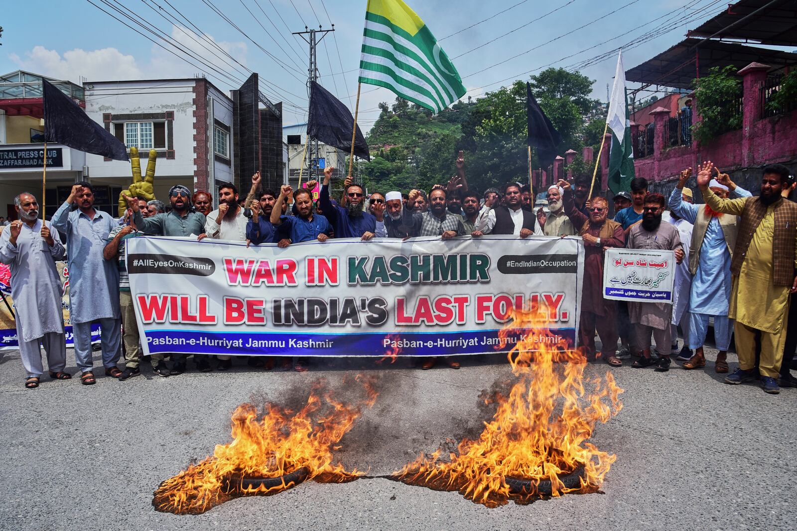 Supporters of Pasban-e-Hurriyat Jammu and Kashmir chant slogans next to burning tires during an anti-India demonstration, in Muzaffarabad, the capital of Pakistan administered Kashmir, Monday, May 5, 2025. (AP Photo/M.D. Mughal)