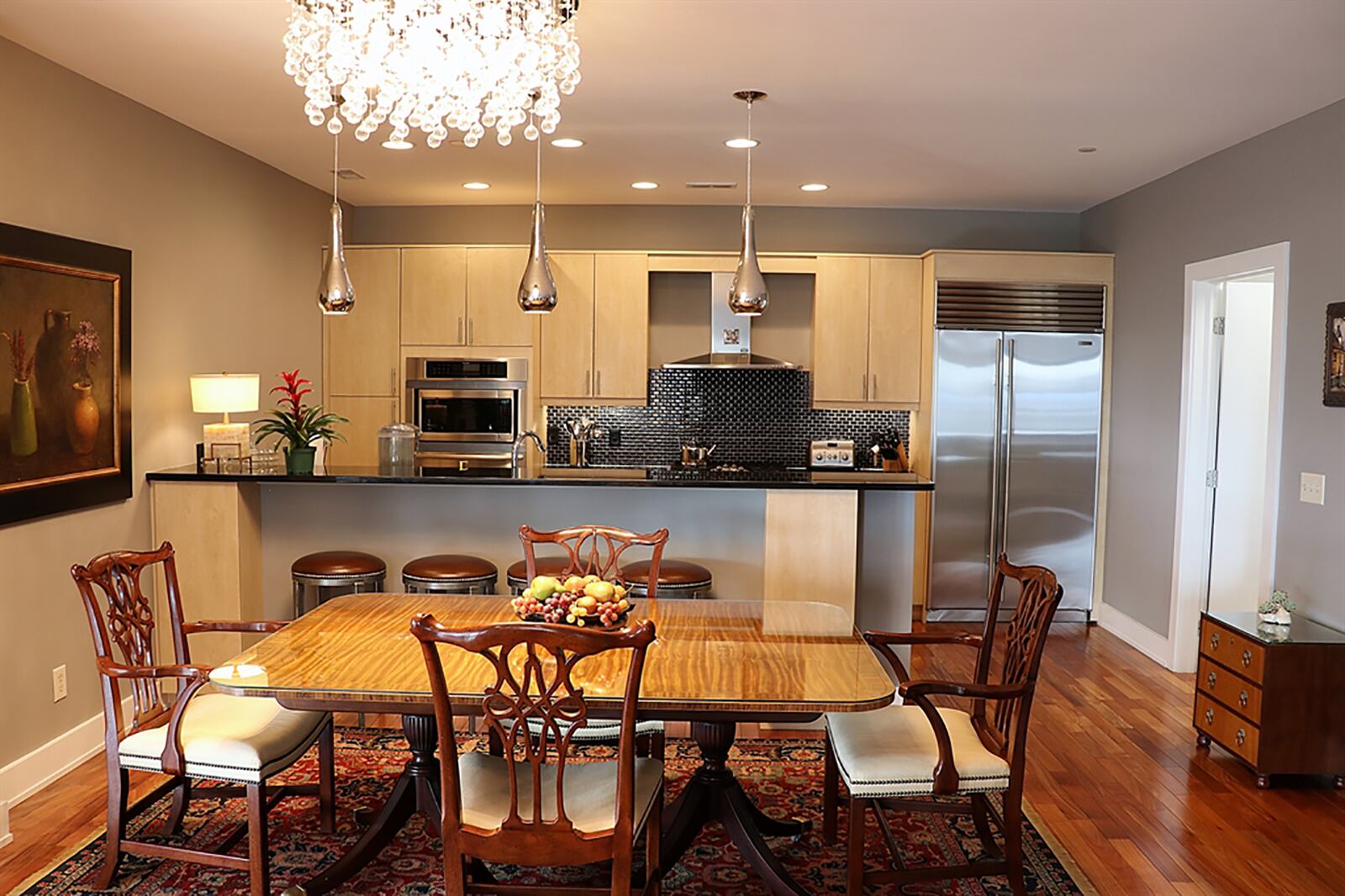A long peninsula two-level countertop divides the kitchen from the dining area, yet also offers breakfast bar seating for up to six. Dark granite countertops complement the light wood contemporary cabinetry. CONTRIBUTED PHOTO BY KATHY TYLER