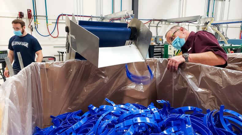 Aaron Matta, left, and Randy Hughes make adjustments as they produce headbands for face masks at IMFLUX Friday, April 24 in Hamilton. IMFLUX has started making face masks and swabs to help during the coronavirus (COVID-19) pandemic. IMFLUX machines custom molds for their injection molding process and has created molds to make these products in their facility on Symmes Road. NICK GRAHAM / STAFF