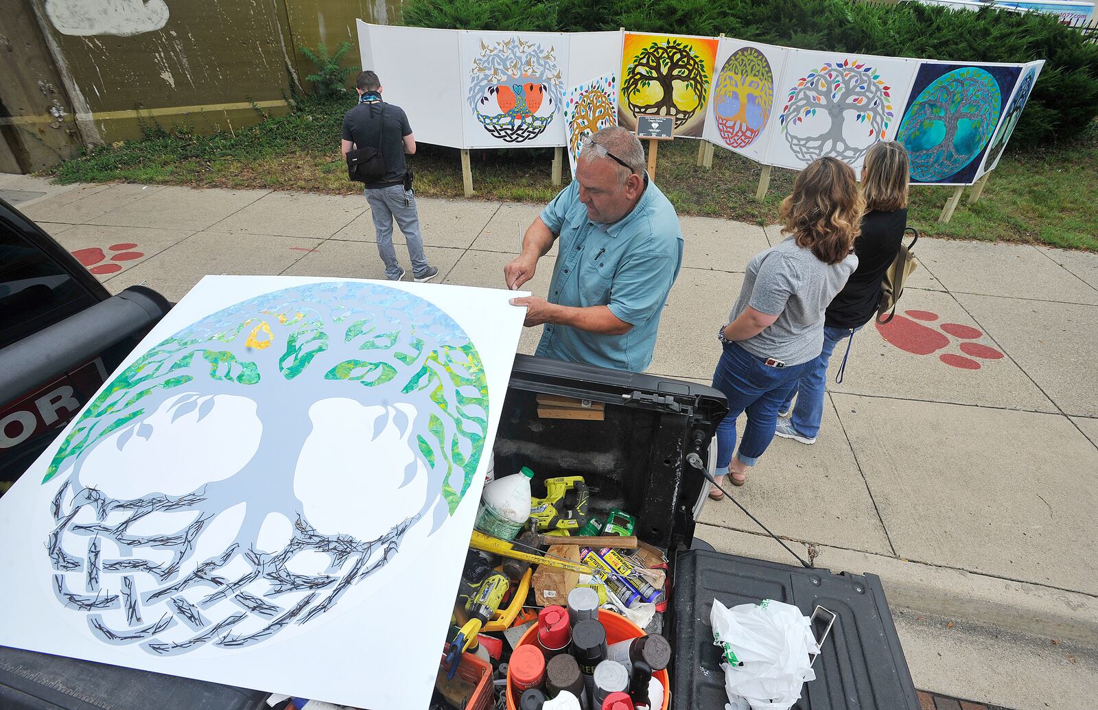 Richard Lundin, prepares one of the nine paintings in 2020 for a temporary memorial on Fifth Street.