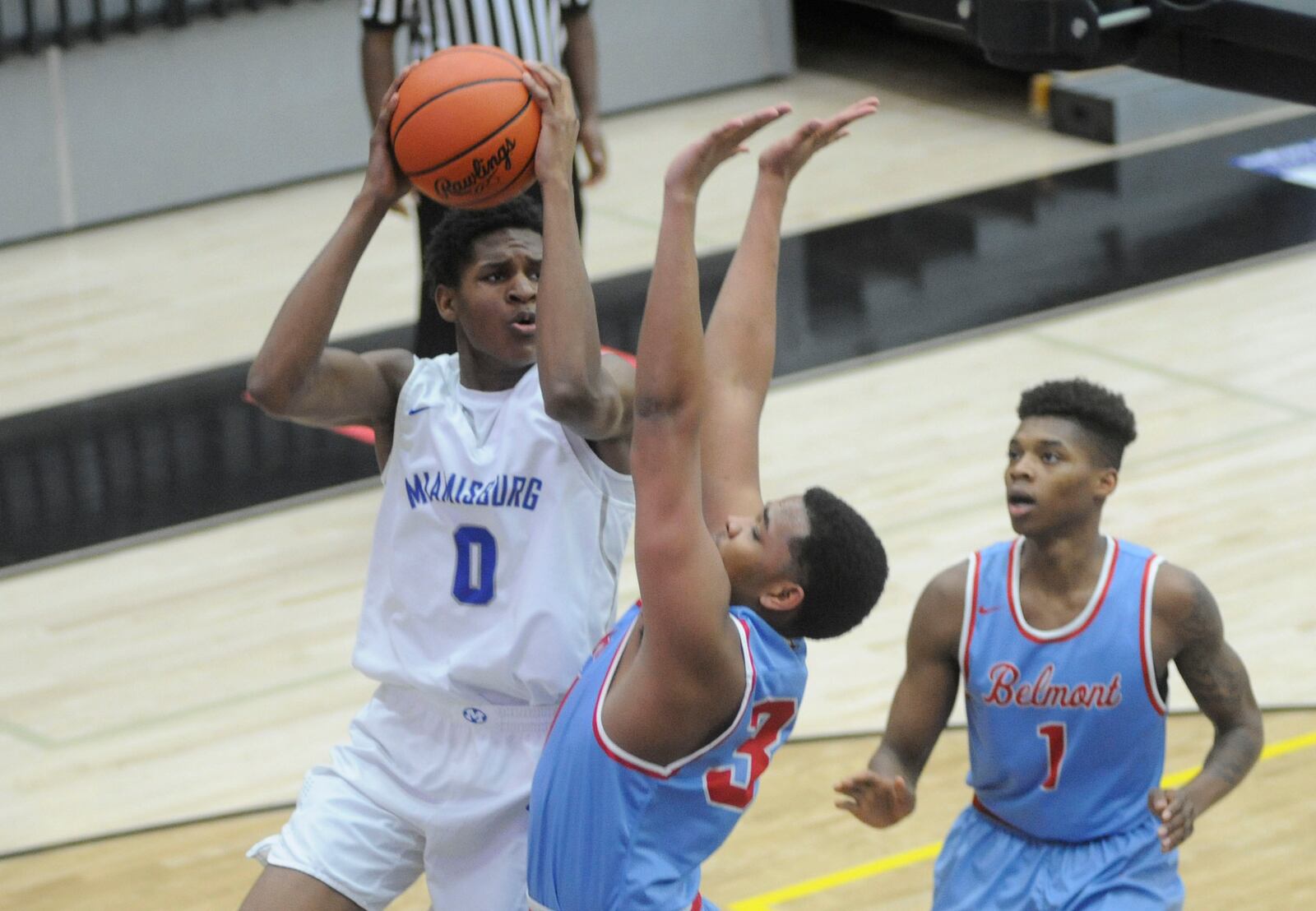 Miamisburg’s Jason Hubbard works against Belmont’s Latrell Estes (middle) and Jeff Hunt. MARC PENDLETON / STAFF
