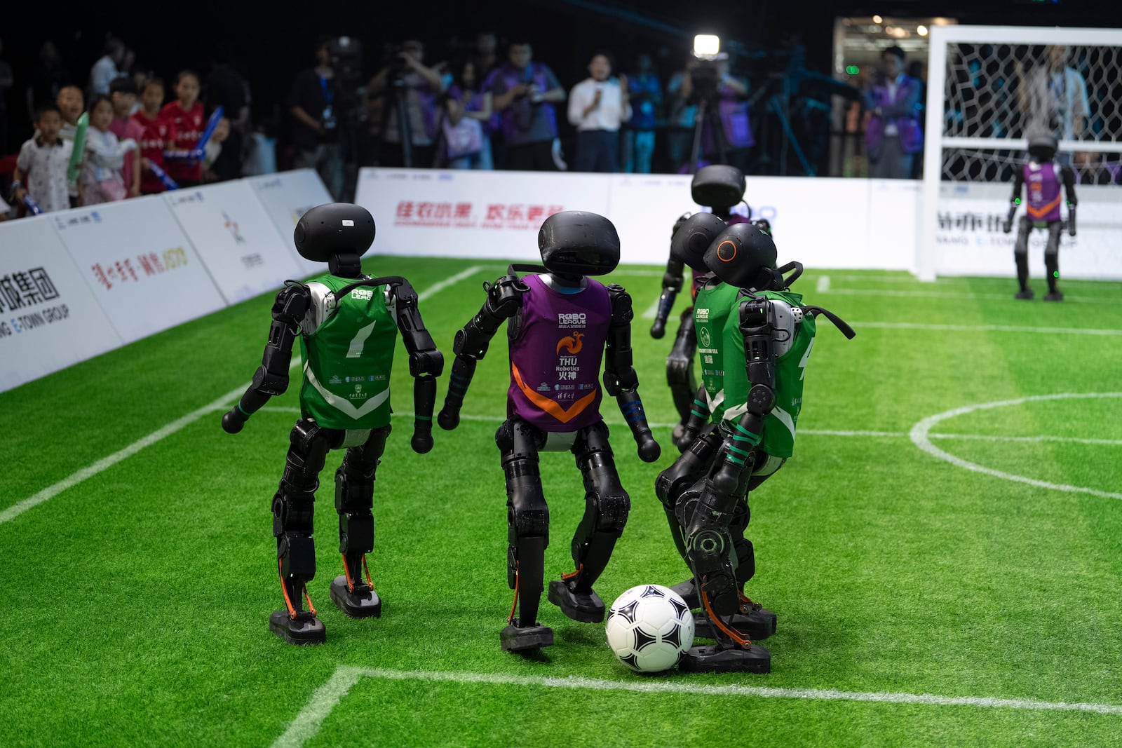 Teams using autonomous T1 robots from Booster Robotics compete in the inaugural RoBoLeague robot soccer competition held in Beijing, Saturday, June 28, 2025. (AP Photo/Ng Han Guan)