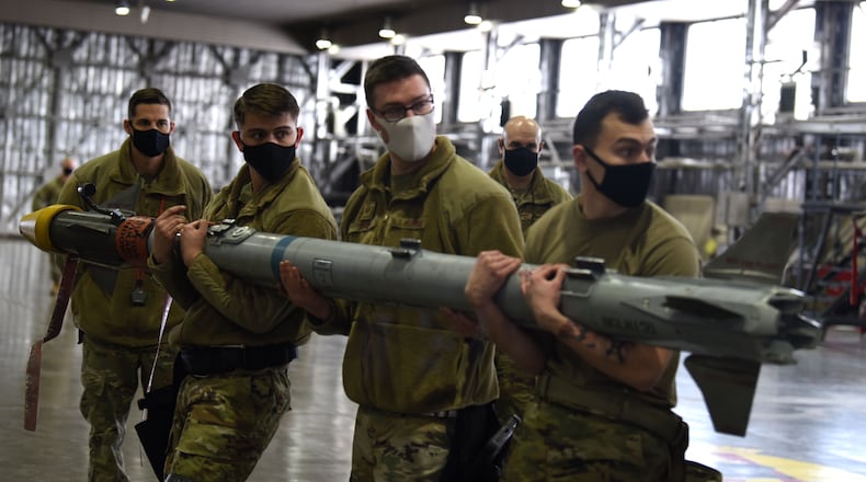 Airmen with the 14th Aircraft Maintenance Unit prepare to load a training AIM-9X, a short-range air-to-air missile, onto an F-16 Fighting Falcon during the annual weapons load competition at Misawa Air Base, Japan Jan. 20, 2021. Expert weapons technicians evaluate participants from both teams on various aspects such as safety, accuracy, tool accountability and dress and appearance. (U.S. Air Force photo by Staff Sgt. Grace Nichols)
