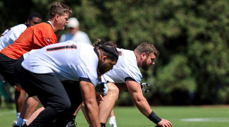 Cincinnati Bengals' Ted Karras, right, sets prior to the play as Joe Burrow gets in position during a drill at NFL football practice in Cincinnati, Tuesday, May 17, 2022. (AP Photo/Aaron Doster)