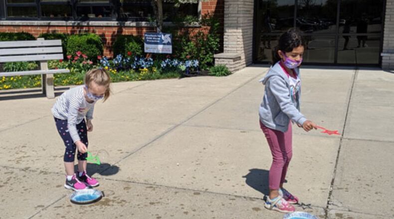 Students at Main Elementary School in Beavercreek take part in a “bubbles and water” experiment during the Wizards of Wright! program presentation in April. (Contributed photo)