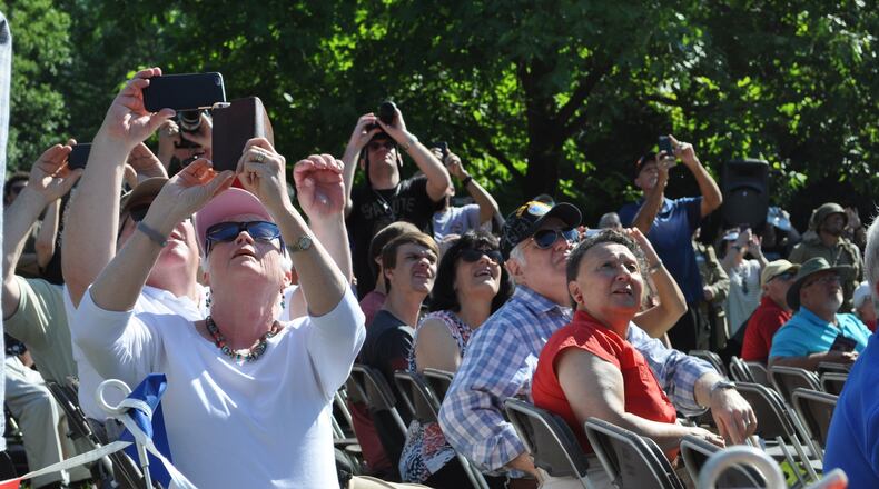 Spectators watch as two C-47 aircraft fly over Memorial Park at the National Museum of the U.S. Air Force on Thursday. The World War II era aircraft flew over the museum as part of a day of events to commemorate the 75th anniversary of D-Day.