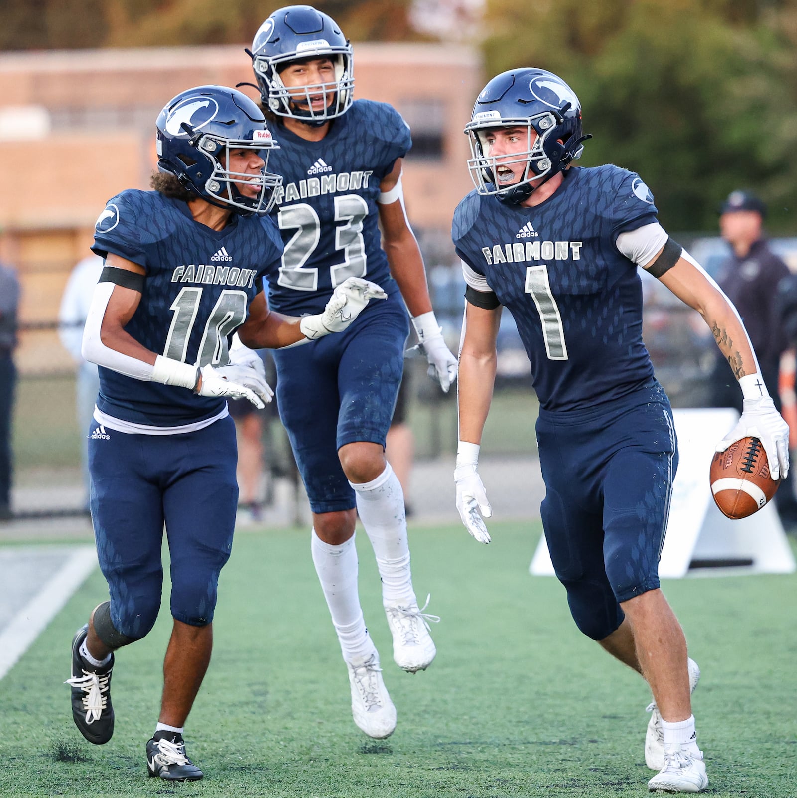 Fairmont senior defensive back Kaleb Moore (right) celebrates with Davion Rand (left) and Adam Grant (center) after an interception at the end of the second quarter of a nonconference game against Trotwood-Madison on Friday. Aug. 29 at Roush Stadium in Kettering. BRYANT BILLING / STAFF