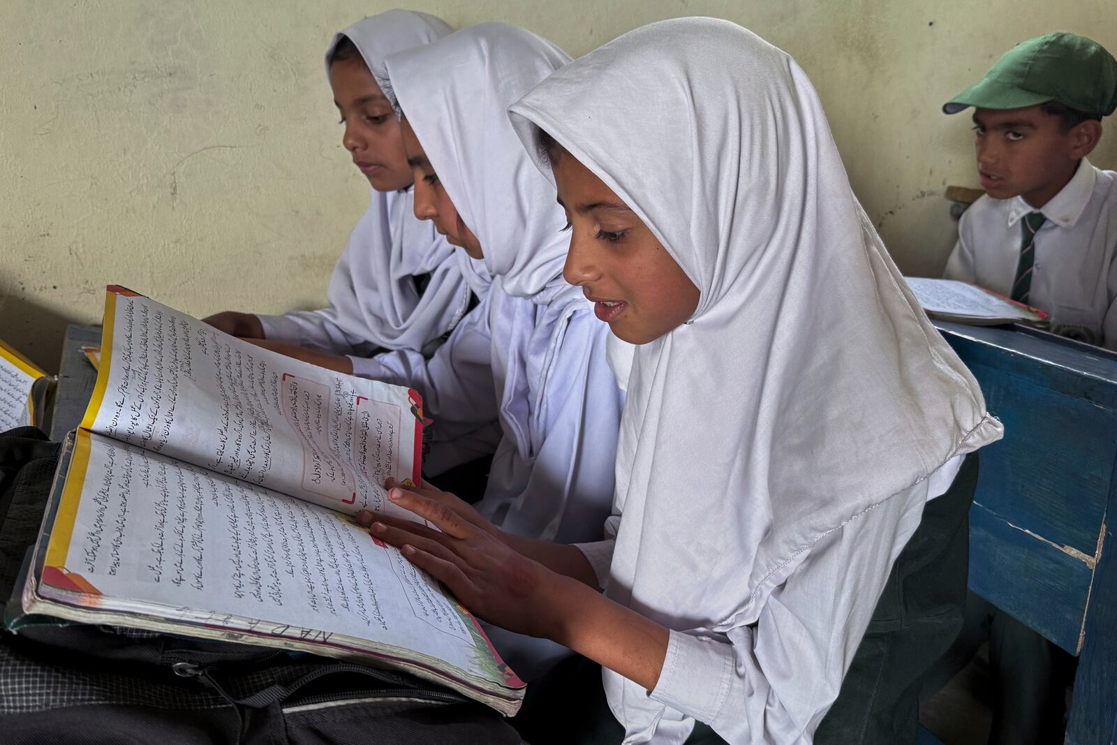 Students attend their class in Aligarh School and College of Commerce and Science in Dara Batang during a government's organized trip for media to Bella Noor Shah, a mountainous village near Muzaffarabad, the capital of Pakistan administered Kashmir, Monday, May 5, 2025. (AP Photo/Muhammad Yousuf, Pool)