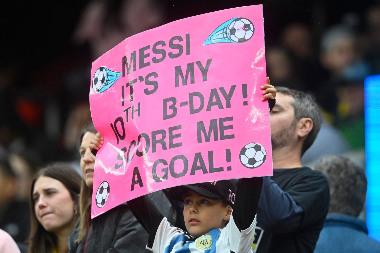 A fan holds a sign during the first half of an MLS soccer match between the Columbus Crew and Inter Miami, Saturday, April 19, 2025, in Cleveland, Ohio. (AP Photo/David Richard)