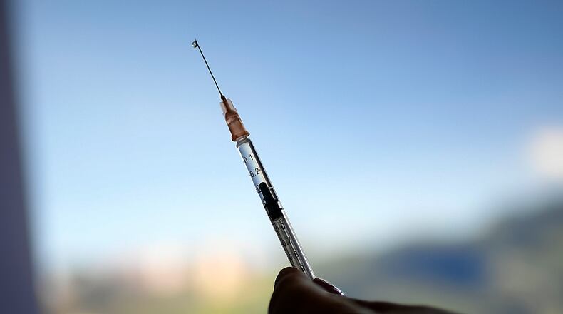 FILE - A healthcare worker prepares a dose of the Sputnik V vaccine for COVID-19 as seniors and those considered high risk for contagion are eligible at a vaccination center set up in the parking lot of the Armed Forces Social Prevision Institute (IPSFA) in Caracas, Venezuela, June 7, 2021. (AP Photo/Matias Delacroix,. File)