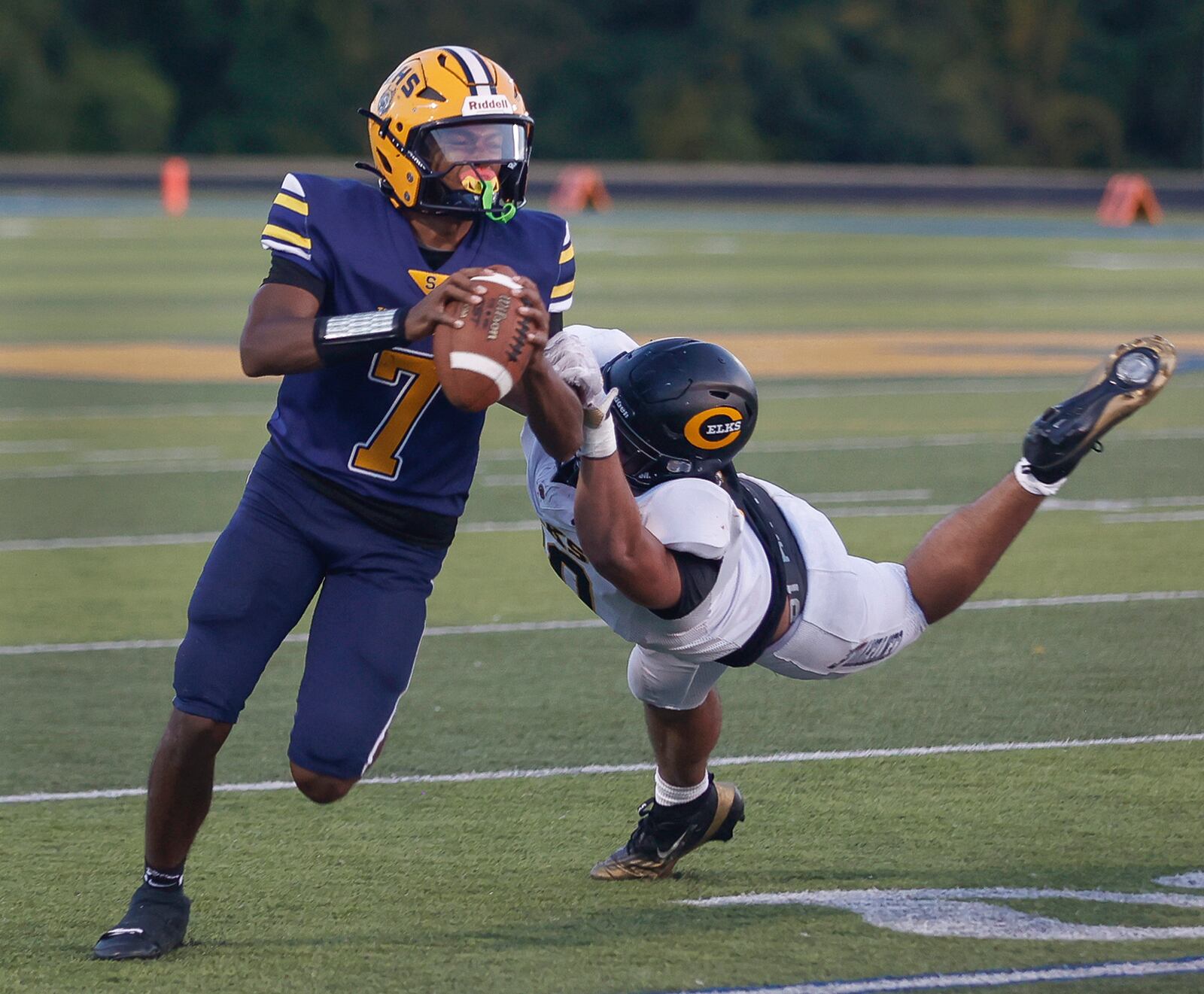 Springfield's Christopher Wallace (#7) runs with the ball as Centerville's Levi Anderson (#30) tries to tackle him during a game on Friday, September 19, 2025, at Springfield High School. JOSEPH COOKE/STAFF