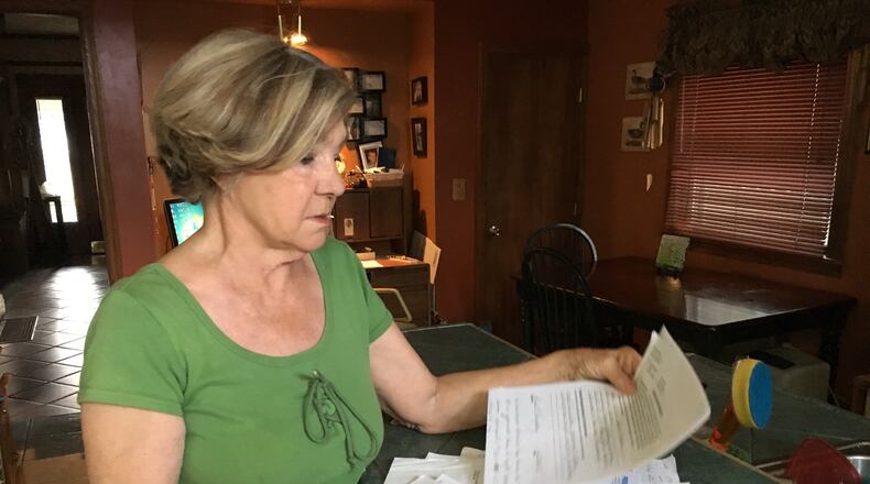 Paula Humphrey displays some of the denial letters she received from the Ohio Victims of Crime Compensation Program after she was brutally assaulted in her Dayton home. Humphrey says she faced insurmountable bureaucracy in the program until she learned she could get an attorney at no charge.