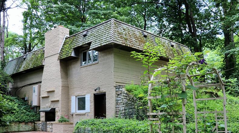 The property comes with a paver brick patio with wood-burning fireplace and a circular driveway with bridge over the creek bed.