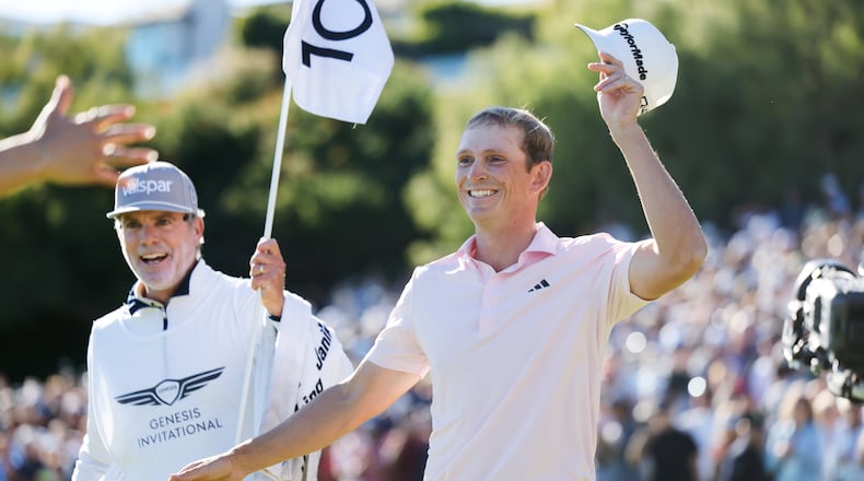 Jacob Bridgeman smiles next to caddie GW Cable after winning the Genesis Invitational golf tournament at Riviera Country Club, Sunday, Feb. 22, 2026, in the Pacific Palisades area of Los Angeles. (AP Photo/Caroline Brehman)