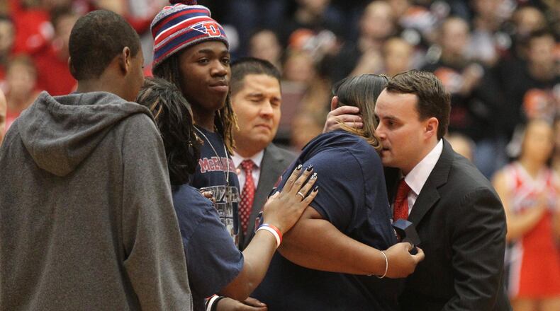 Dayton coach Archie Miller hugs Steve McElvene’s mom Jenell Shoals during a pregame ceremony before a game against Austin Peay on Friday, Nov. 11, 2016, at UD Arena. David Jablonski/Staff