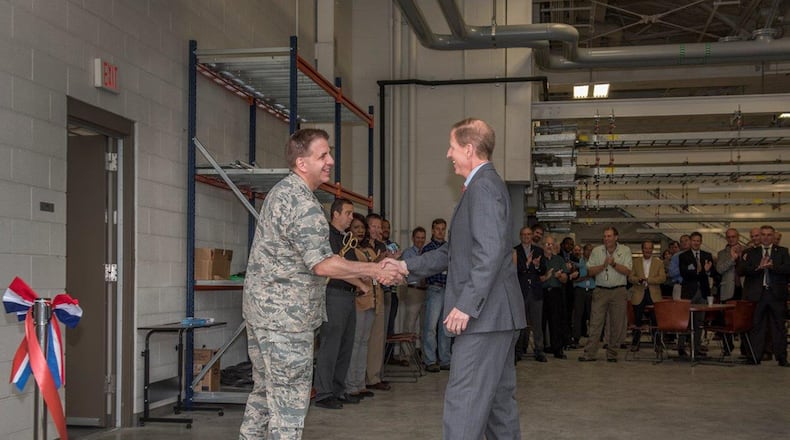 Col. Joel Luker (left), Air Force Research Laboratory Aerospace Systems deputy director, and Christopher Greek, AFRL Power and Control division chief, shake hands during a ribbon-cutting ceremony at Bldg. 19, Wright-Patterson Air Force Base, Sept. 14. The Bldg. 19 design concept provides a flexible and reconfigurable research space to house applied research in aircraft systems integration. (U.S. Air Force photos/Michelle Gigante)
