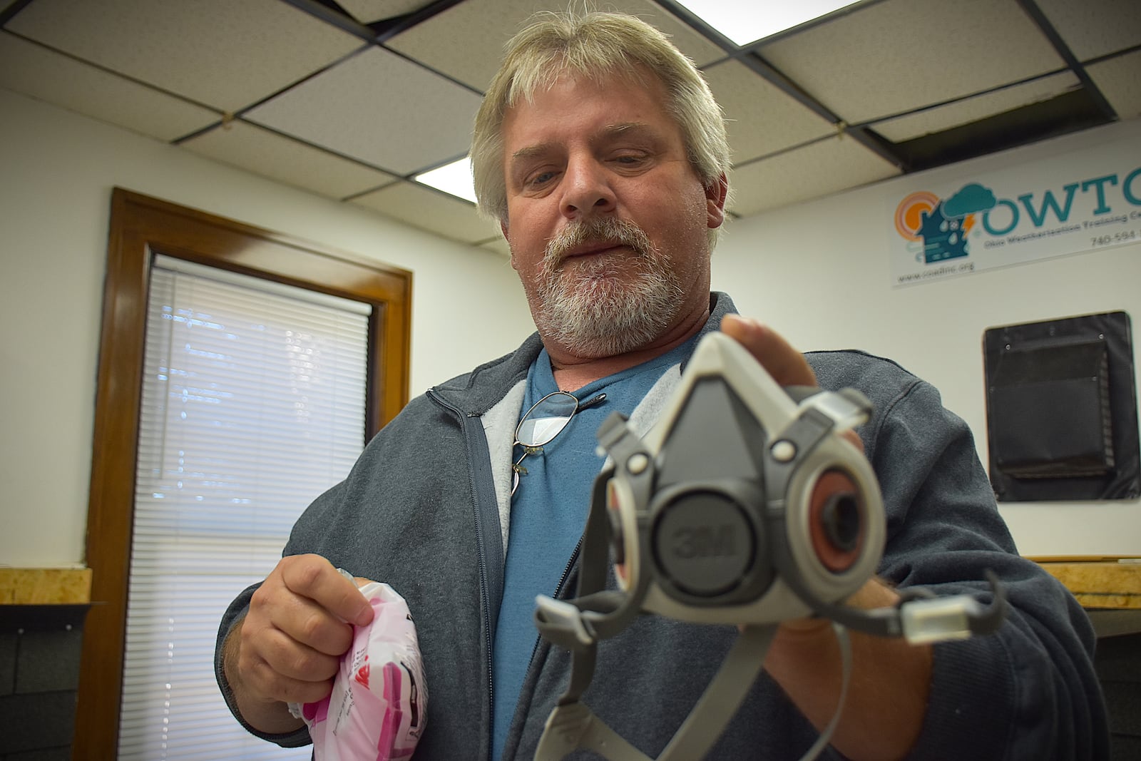Frank Branson, quality control inspector with Miami Valley Community Action Partnership, holds a respirator that crews wear when they work in homes with lead paint. CORNELIUS FROLIK / STAFF