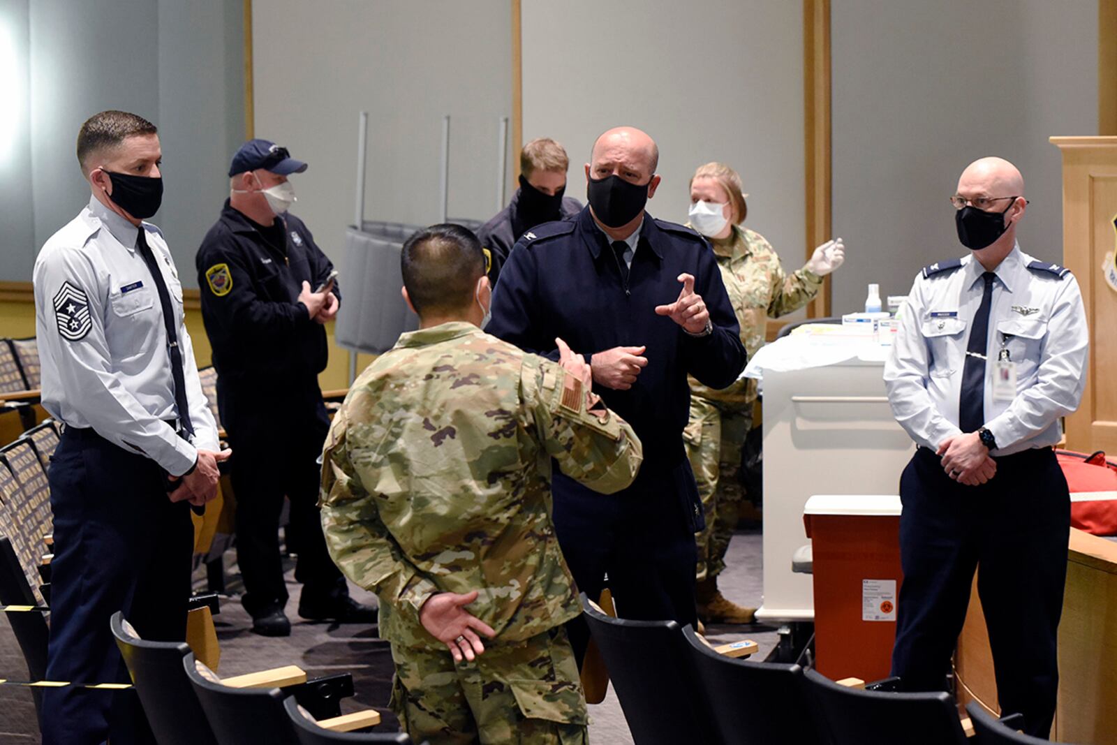Col. Patrick Miller (center), 88th Air Base Wing and installation commander, is briefed by 88th Medical Group personnel Jan. 4 as the COVID-19 vaccine is administered at Wright-Patterson Air Force Base. Portions of this photo have been altered for security reasons. U.S. AIR FORCE PHOTO/TY GREENLEES