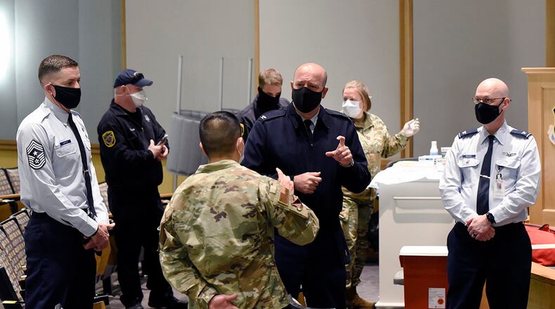 Col. Patrick Miller (center), 88th Air Base Wing and installation commander, was briefed by 88th Medical Group personnel Jan. 4 as the COVID-19 vaccine is administered at Wright-Patterson Air Force Base. Portions of this photo have been altered for security reasons. U.S. AIR FORCE PHOTO/TY GREENLEES