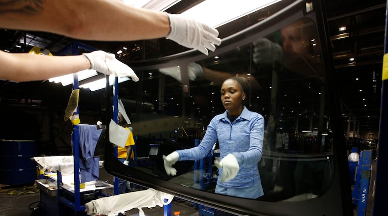 Fuyao Glass America workers Dustin Sparkman, left, and Deraesha Stewart work as a team to clean and quality check windshields in the Moraine plant in this 2016 photo. TY GREENLEES / STAFF