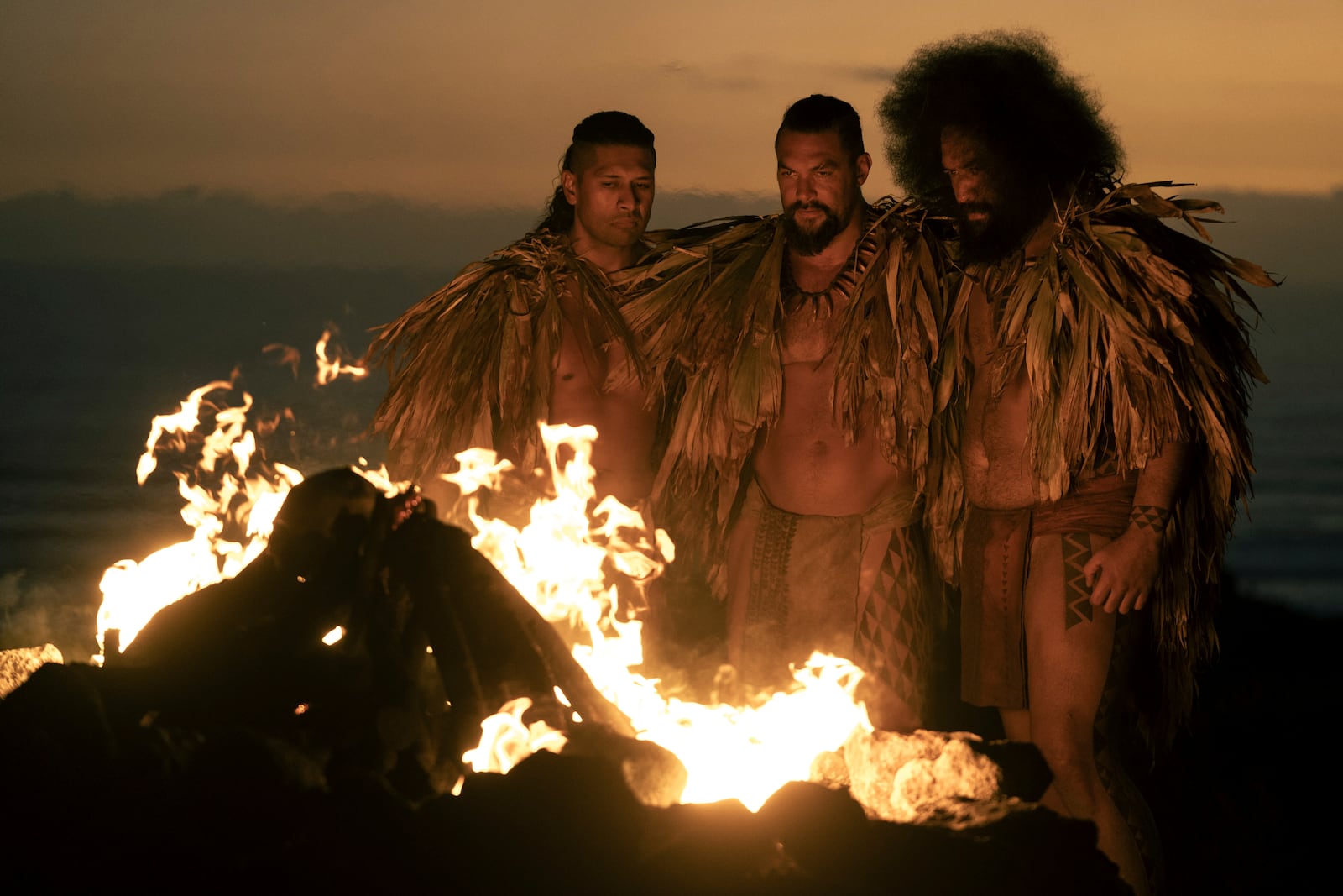This image released by Apple TV+ shows Te Kohe Tuhaka, from left, Jason Momoa and Siua Ikale'o in a scene from "Chief of War." (Nicola Dove/Apple TV+ via AP)