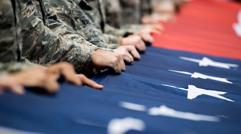FILE: Airmen from Wright-Patterson Air Force Base, Ohio, hold a large, garrison-size American flag at half court during pregame ceremonies prior to the NCAA First Four Tournament at the University of Dayton Arena in Dayton, Ohio, March 14, 2018. During the game’s halftime events, Lt. Gen. Robert McMurry Jr., Air Force Life Cycle Management Center commander, also administered the oath of enlistment to delayed enlistment to 32 personnel. (U.S. Air Force photo by Wesley Farnsworth)
