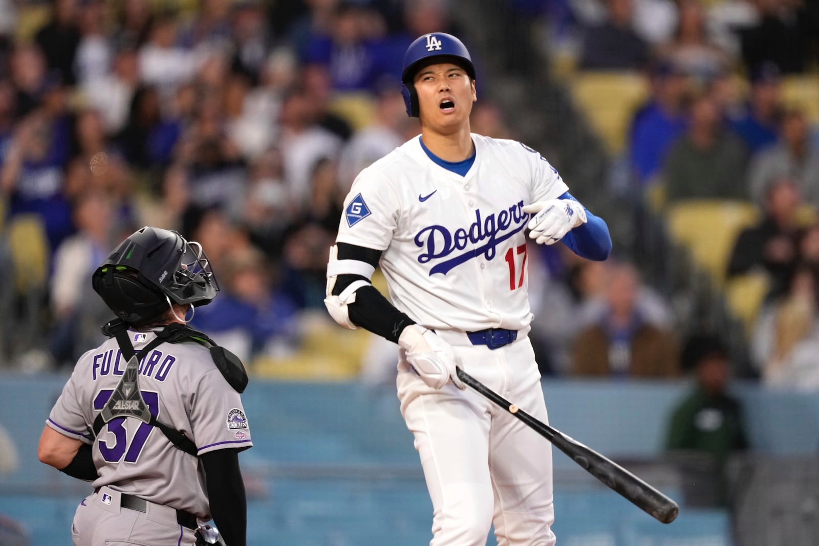 Los Angeles Dodgers' Shohei Ohtani reacts after hitting a foul ball as Colorado Rockies catcher Braxton Fulford kneels at the plate during the first inning of a baseball game Wednesday, April 16, 2025, in Los Angeles. (AP Photo/Mark J. Terrill)