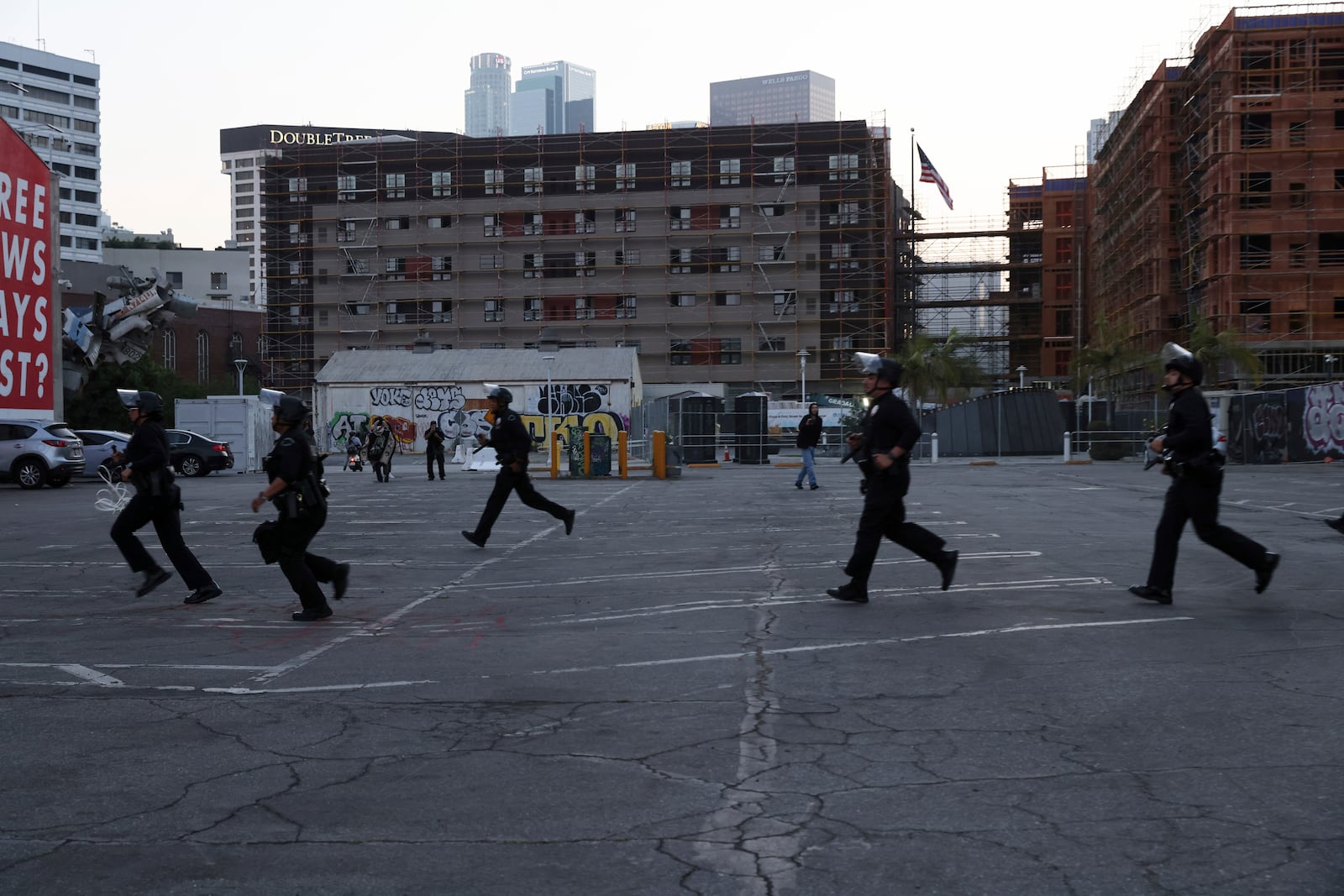 Los Angeles police officers stand by while protesters rally during a demonstration in response to a series of United States Immigration and Customs Enforcement (ICE) raids throughout the country, in Los Angeles, Calif., Thursday, June 12, 2025. (Gabrielle Lurie/San Francisco Chronicle via AP)