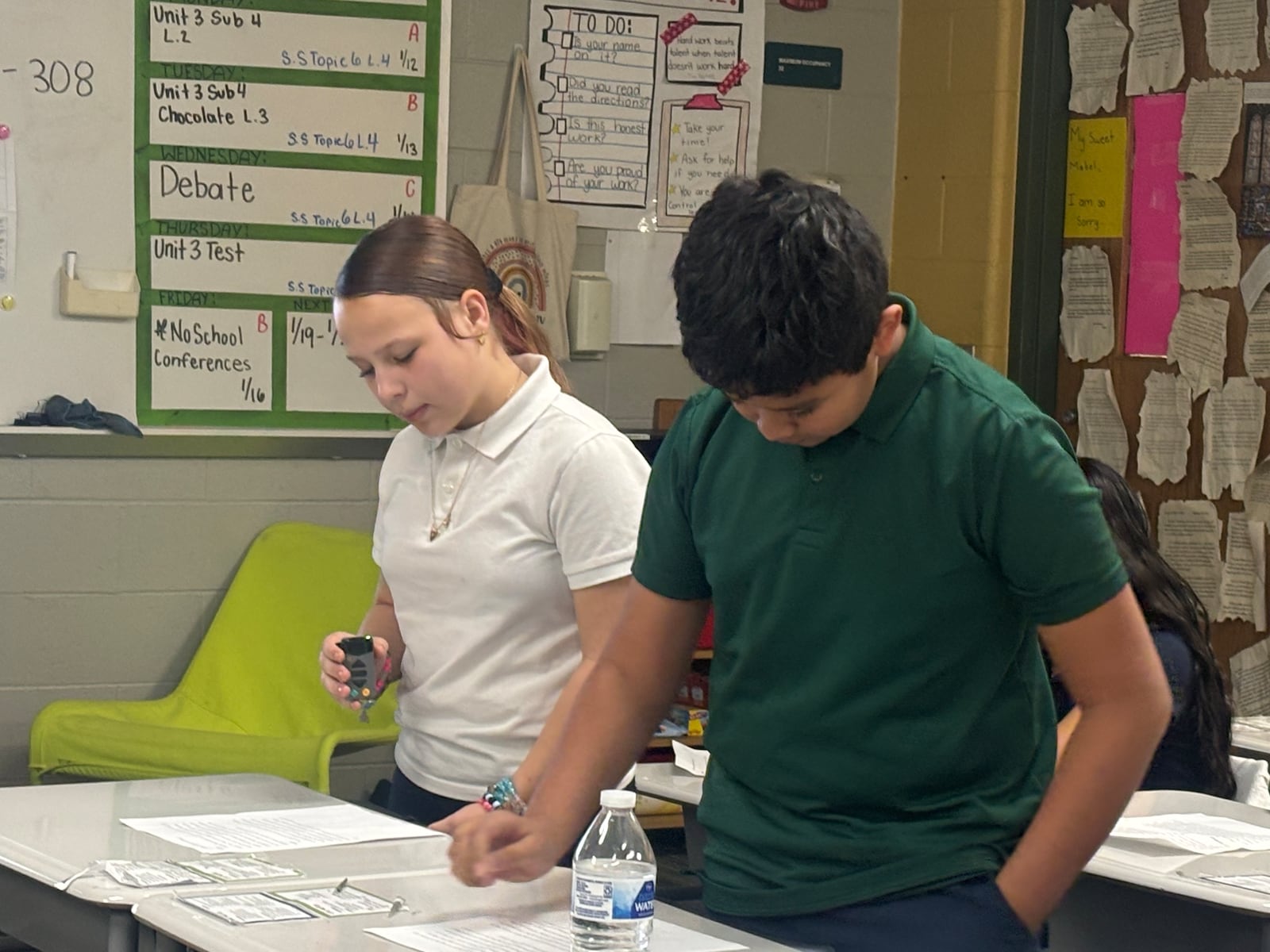 Students in Mrs. Neumann's sixth grade class at Cleveland Elementary read debate points during a class debate over chocolate being included in school lunches. Eileen McClory / staff