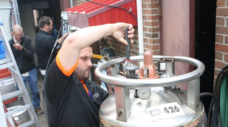 Aaron King, front, works with the three person team from Weiler Welding on the initial CO2 tank installation at Caddy’s Tap House in Beavercreek. The other members of the team are Jeff Ungerecht, back left, and Michael Butler, back right.