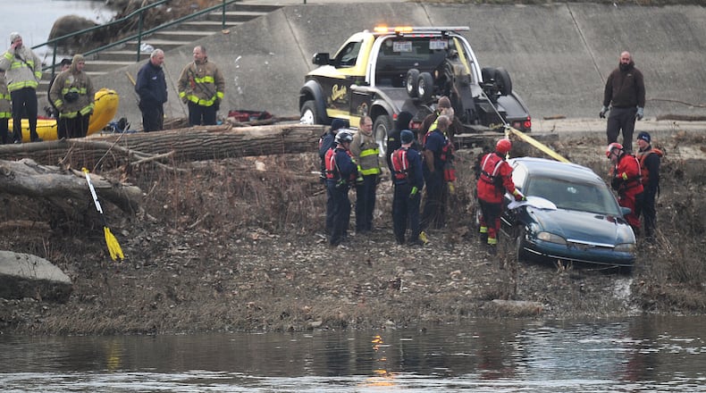 A team from the Dayton Fire Department responded to the Great Miami River just after 2 p.m. on Monday to search for a vehicle that was spotted in the water. A tow truck helped to recover the vehicle, and a sheet was placed on the back window as it emerged from the water. MARSHALL GORBY/STAFF