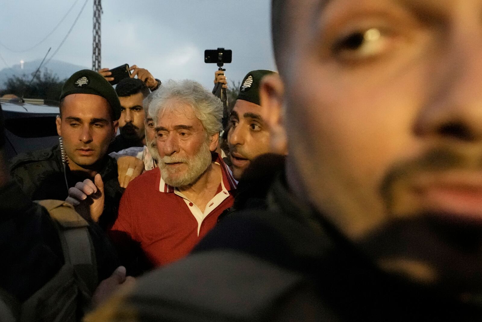 Lebanese pro-Palestinian militant Georges Abdallah, right, who was serving a life sentence for complicity in the 1982 murders of an American and an Israeli diplomat in Paris, is greeted by supporters and surrounded by security forces upon his arrival in Qobayat village, in northern Akkar province, Lebanon, Friday, July 25, 2025. (AP Photo/Hassan Ammar)