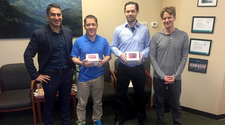Forever Labs CEO Steven Clausnitzer; clients Dan Dascalescu and Max Marty; and Forever Labs president Mark Katakowski pose in a clinic in Orinda. Dascalescu and Marty hold stem cells that have been extracted from their bone marrow. (Forever Labs)