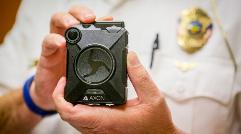 Sgt. Brian Robinson of the Hamilton Police Department displays an Axon body camera. GREG LYNCH / STAFF